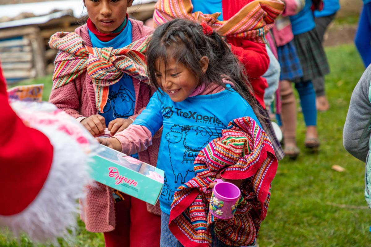 Andean girl happily receiving her Christmas gift | TreXperience