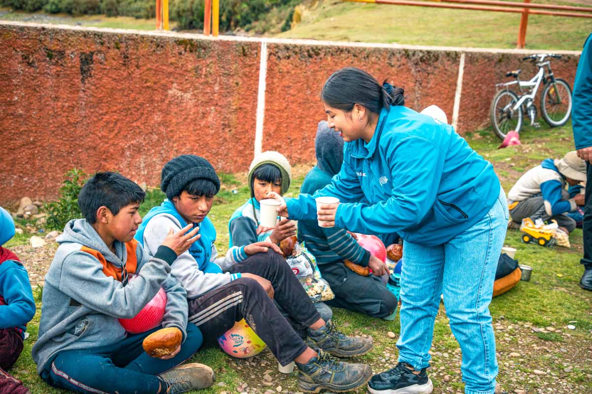 Staff TreXperience reaprtiendo chocolate caliente a niños de Huacahuasi