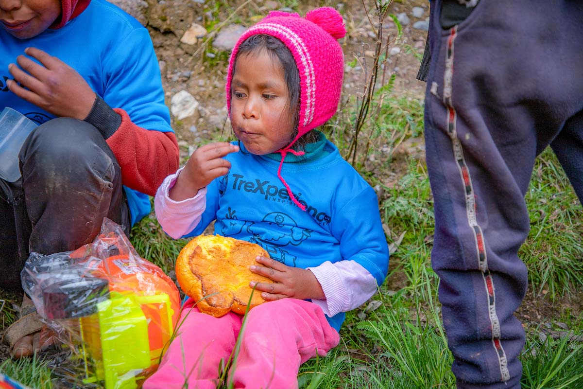 Niña de Pampa Corral comiendo pan dulce | TreXperience