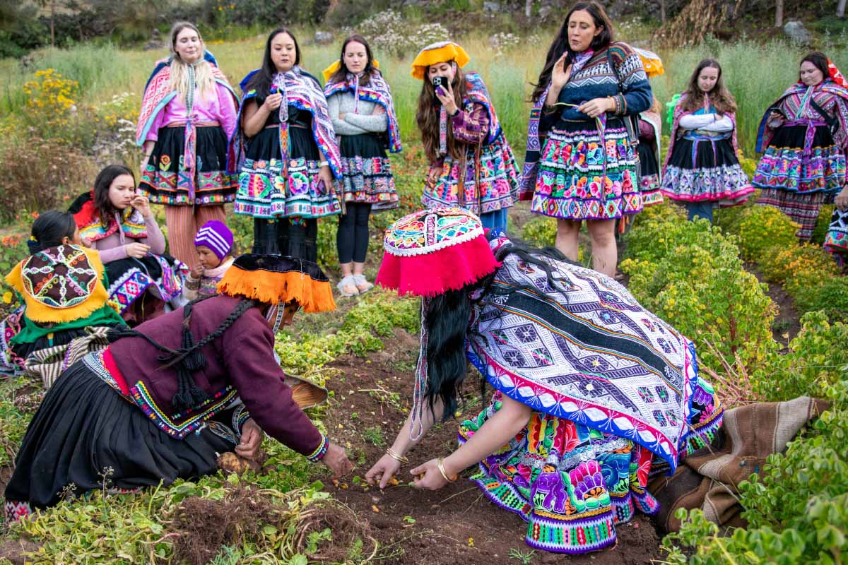 Turista con traje andino y mujer local cosechando papas | TreXperience