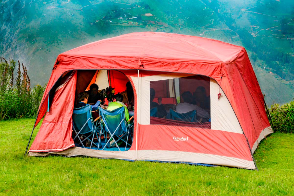 Dining room with open entrance Red dining tent set up on a green area | TreXperience
