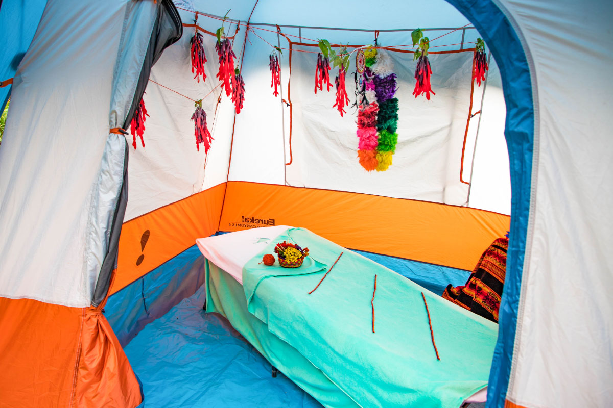 Massage shop decorated with Andean motifs Interior of a massage parlor with a bed covered by a turquoise blanket and colorful hanging decorations | TreXperience