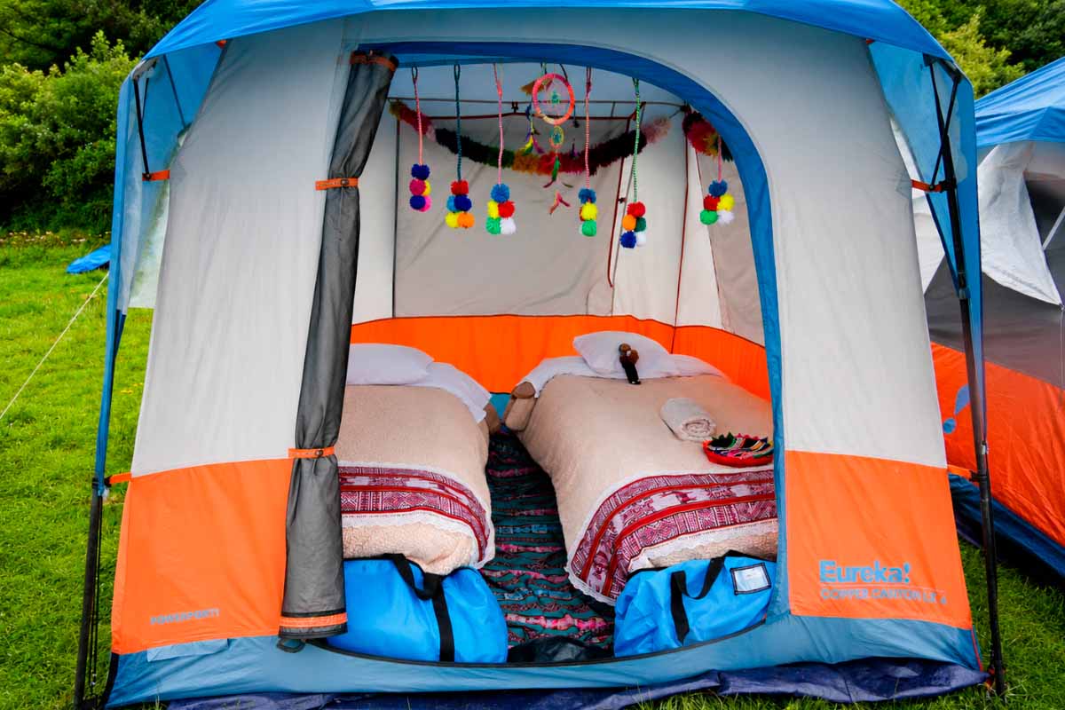 Open tent with two beds inside, decorated Open tent with two beds covered by colorful blankets and pillows inside | TreXperience