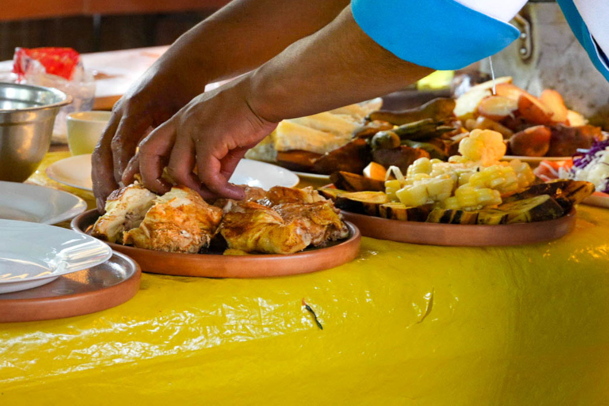 Asistentes de cocina colocando ingrediente sobre un plato de comida servida | TreXperience