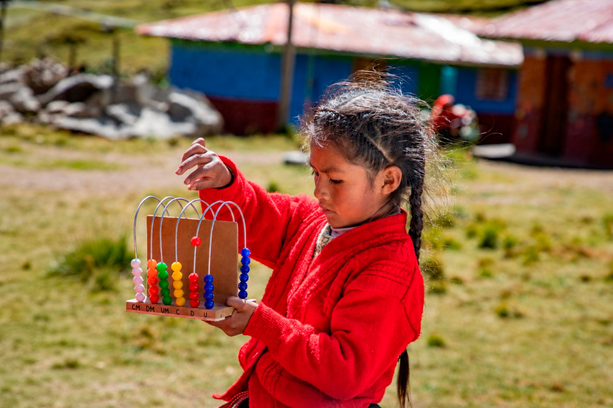 Andean girl playing with an educational abacus | TreXperience
