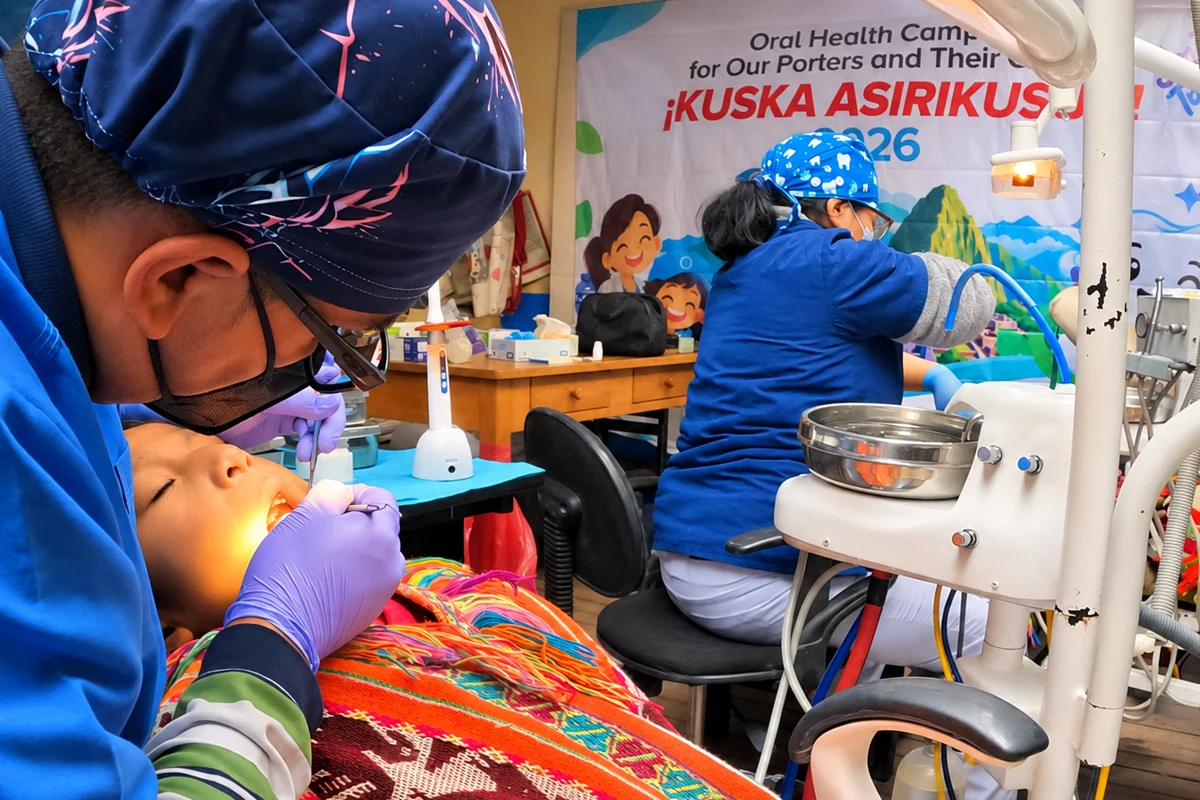 A gloved doctor performs a dental procedure on a reclining child during an oral health campaign A gloved doctor performs a dental procedure on a reclining child during an oral health campaign | TreXperience