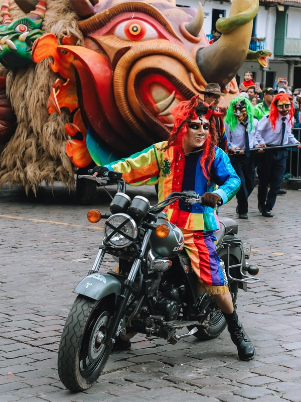 Motorcyclist in Saqra dance attire during the allegorical parade in Cusco | TreXperience