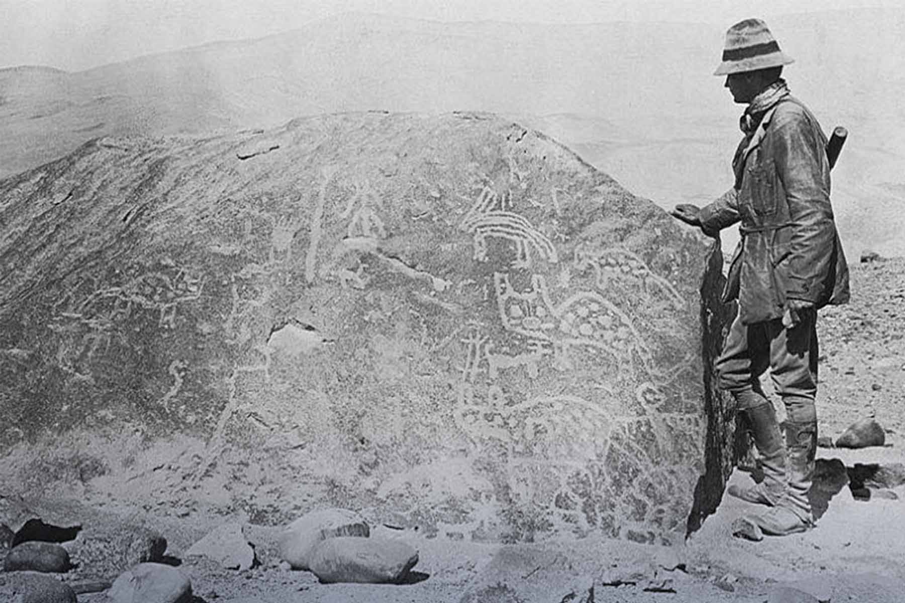 Bingham inspeccionando un petroglifo durante su expedición | TreXperience