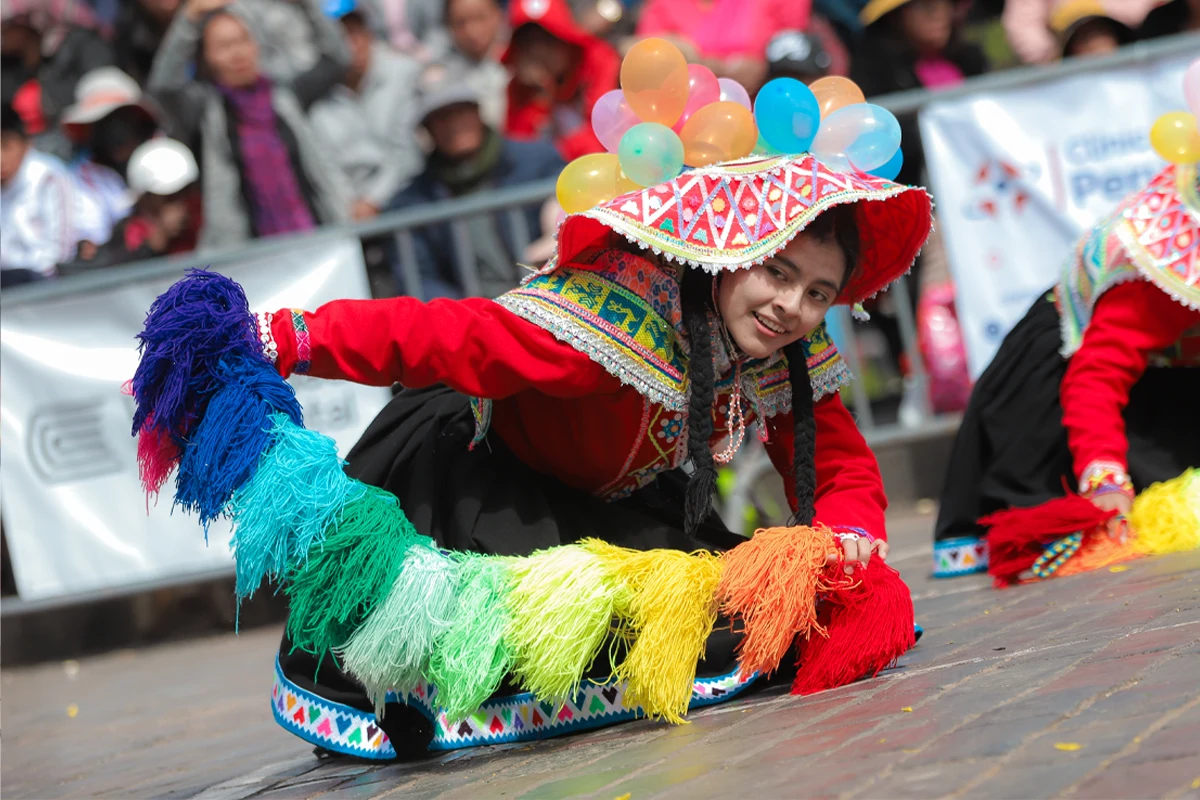 Dancer holding a candunga with the colors of the Cusco flag Bailarina sosteniendo una candunga multicular durante el mes jubilar del Cusco | TreXperience