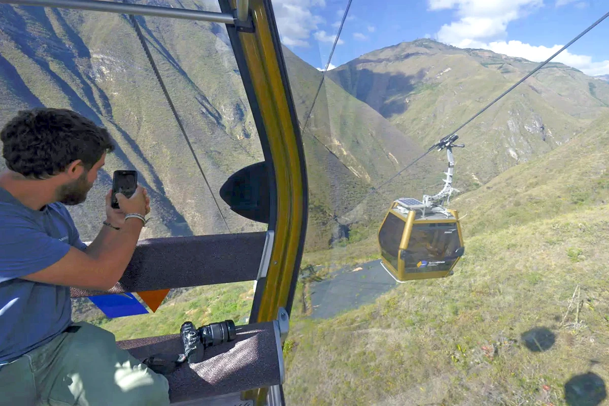 Man enjoying the view from a cable car - Guide to Kuelap | TreXperience