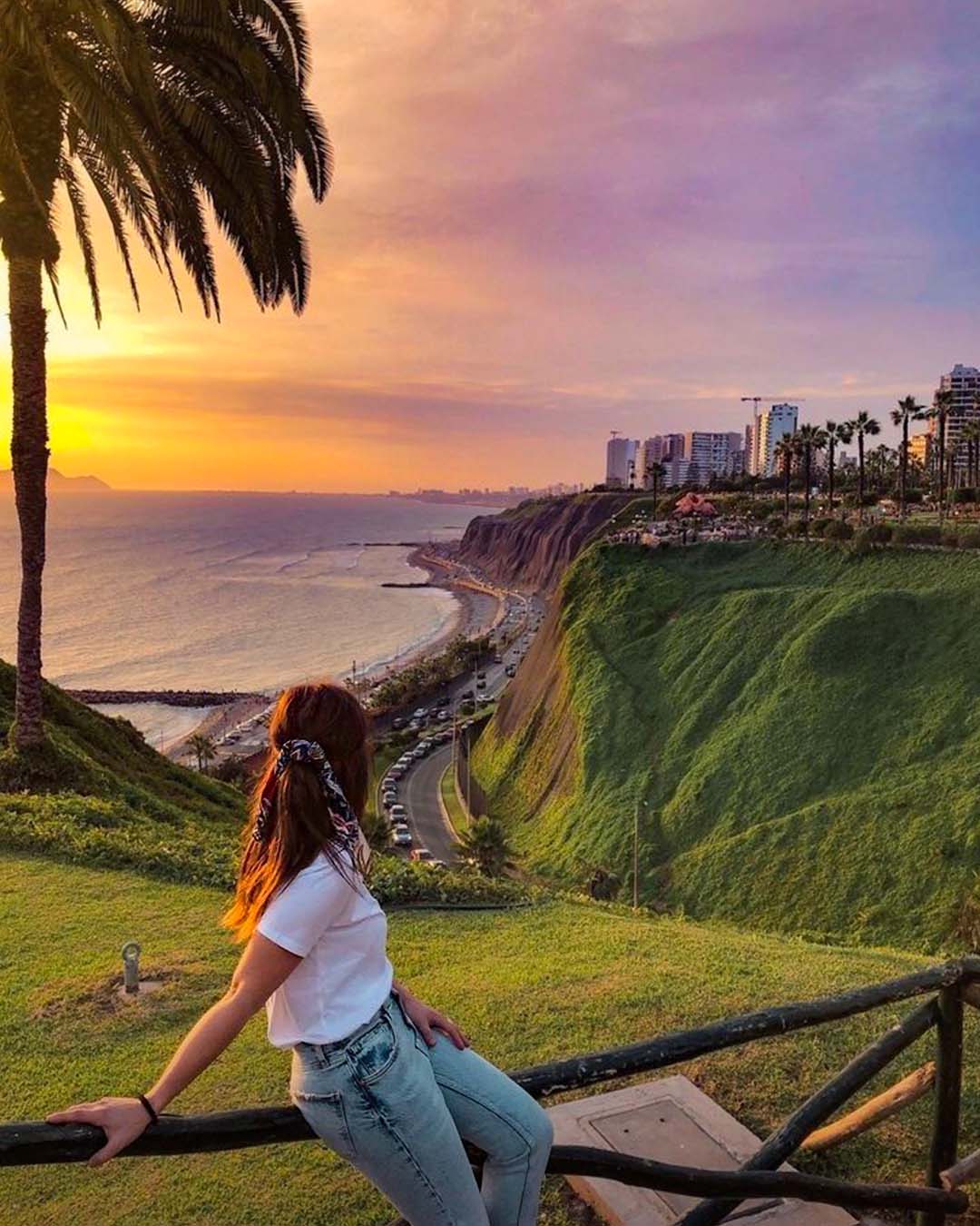 Una mujer viendo el tardecer en la playa de Lima | TreXperience