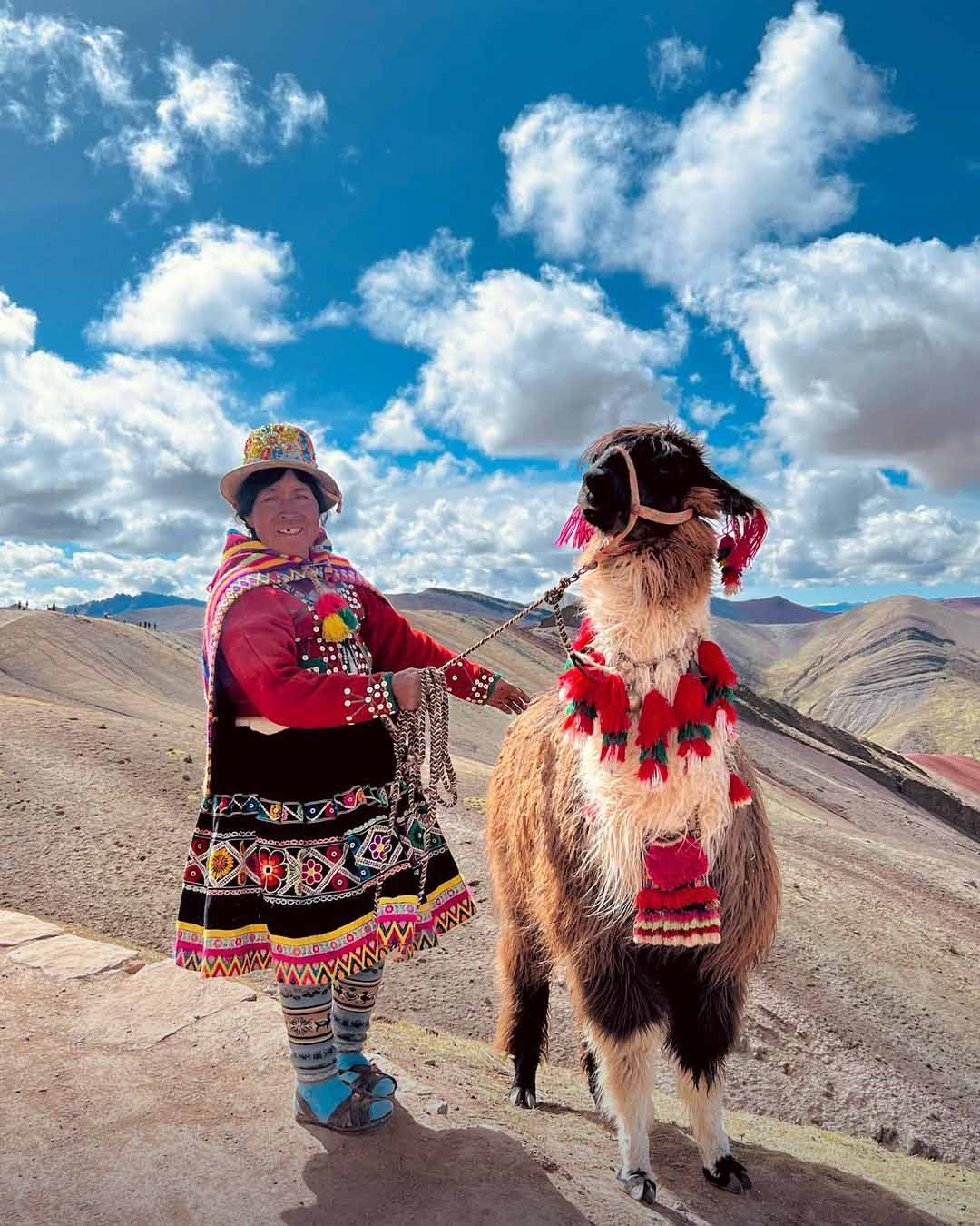 Mujer andina en traje tradicional y su llama en Palccoyo | TreXperience