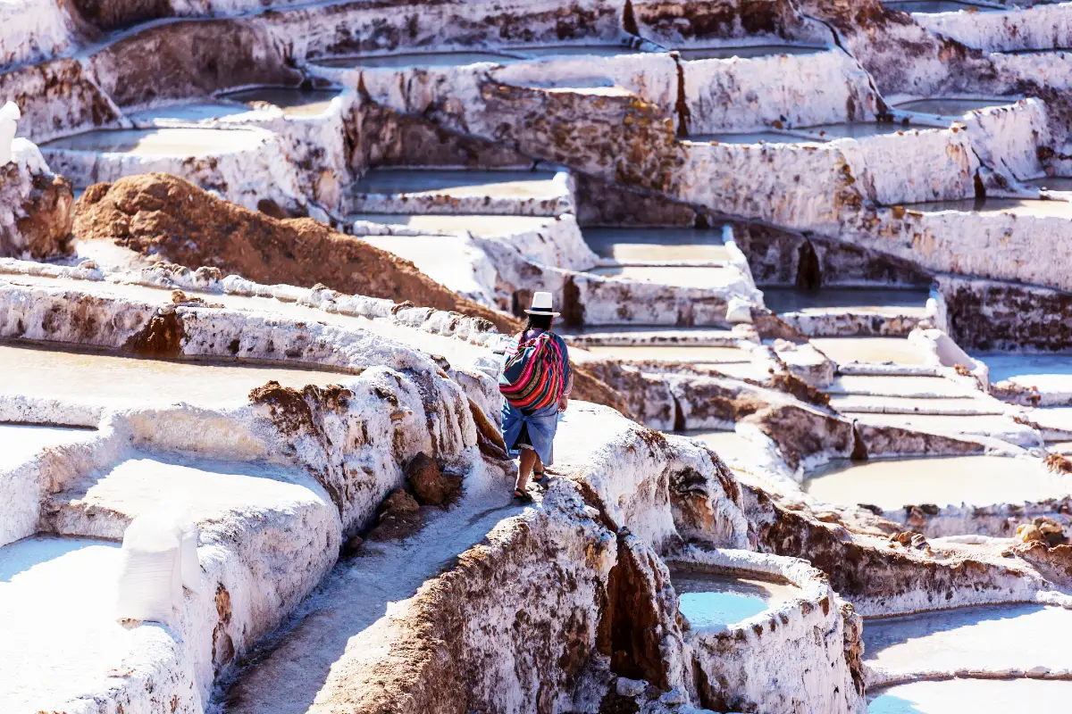 Woman walking through the Maras salt mines | TreXperience Woman walking through the Maras salt mines | TreXperience