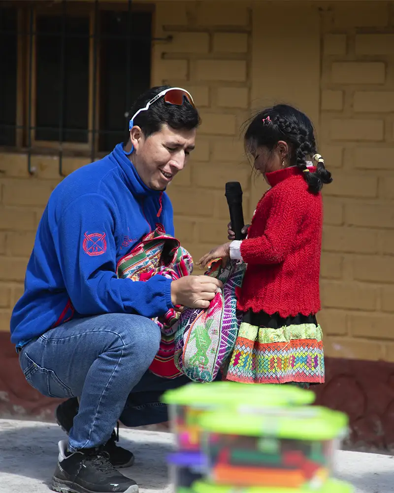 Niña de Qelqanqa entregando bolsa de papas | TreXperience 