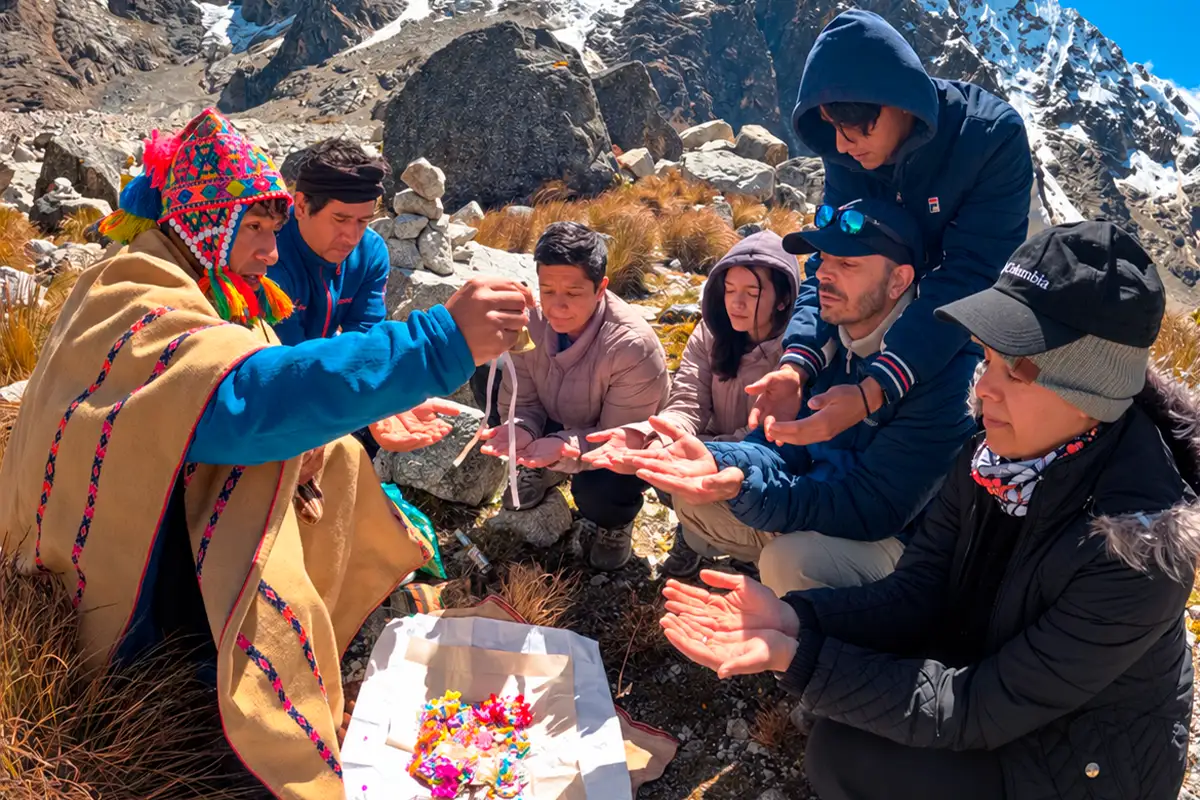 Paco preparing a gift for Pachamama in front of visitors and Salkantay | TreXperience
