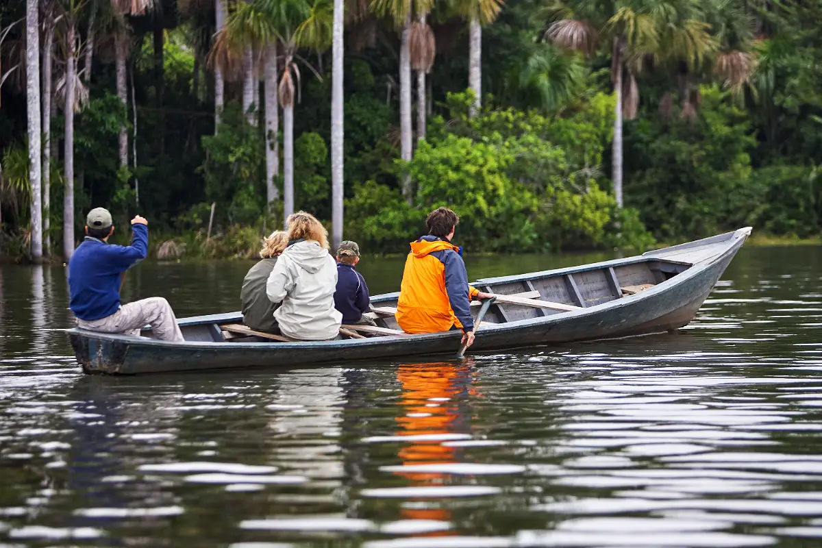 Turistas en bote de madera en Tambopata | TreXperience