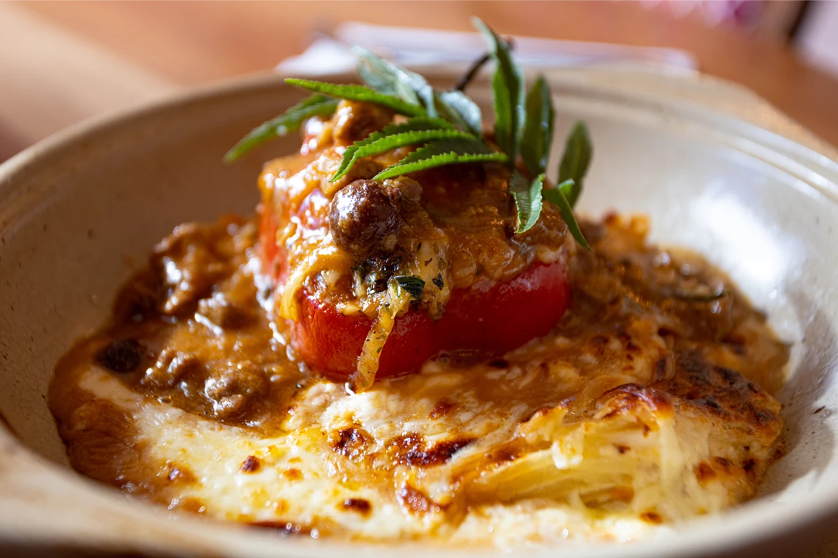 Peruvian stuffed rocoto pepper served alongside a baked spaghetti casserole.
