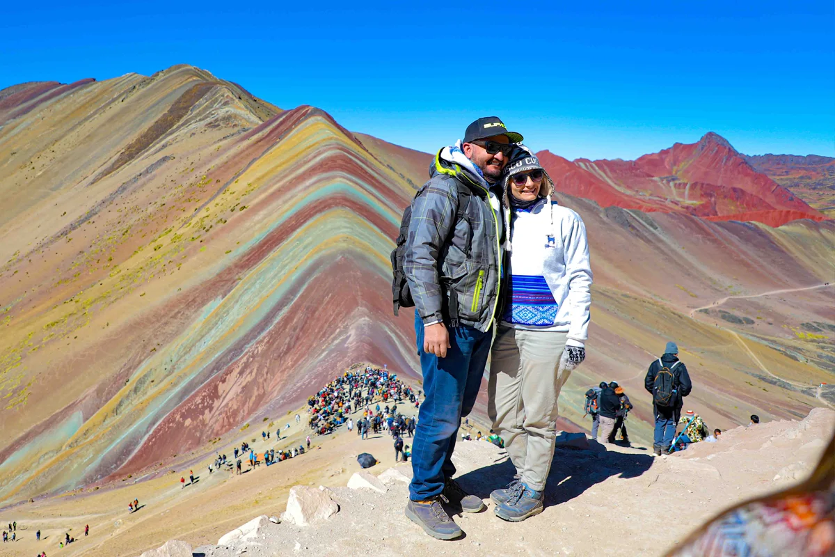 Turistas sonriendo con la Montaña de Colores a sus espaldas