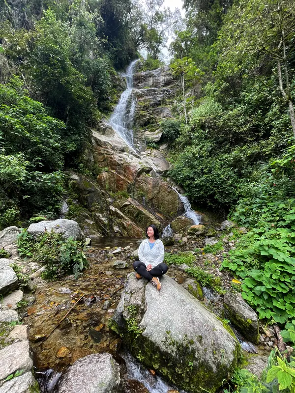 Viajera descansando frente a una cascada en el Camino Inca corto | TreXperience