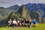 Smiling tourists enjoying their visit to the iconic Inca citadel of Machu Picchu