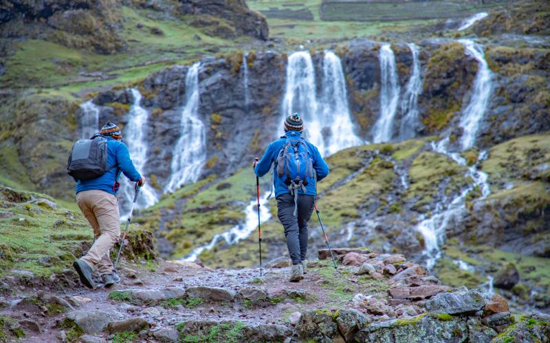 Hiker beside a waterfall in the Lares valley on the Luxury Lares Trek to Machu Picchu