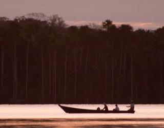 Atardecer sobre el rio Amazonas, el rio reluciente y el bosque a la distancia, parte del tour Camino de los Incas 20 dias