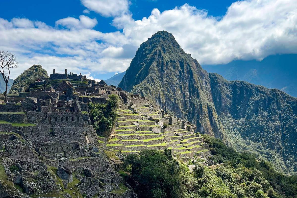Panoramic view of Machu Picchu with stone terraces surrounded by Andean mountains | TreXperience