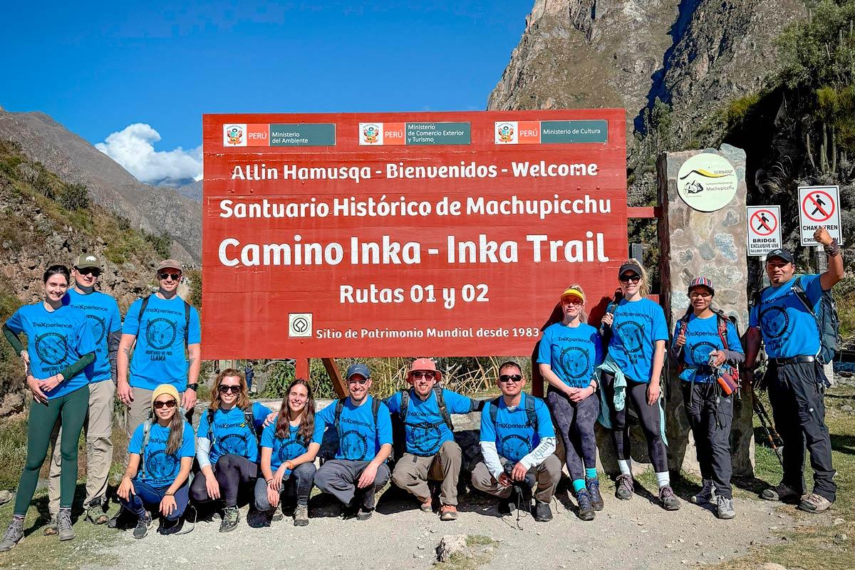 Group of travelers posing next to the Inca Trail sign to Machu Picchu | TreXperience