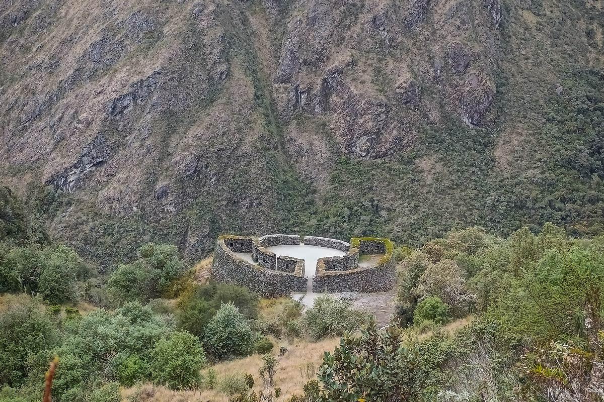 View of a circular stone structure at an archaeological site surrounded by an Andean mountain landscape | TreXperience