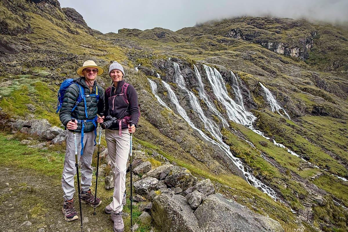 Two hikers in front of Quishuarani Waterfall | TreXperience