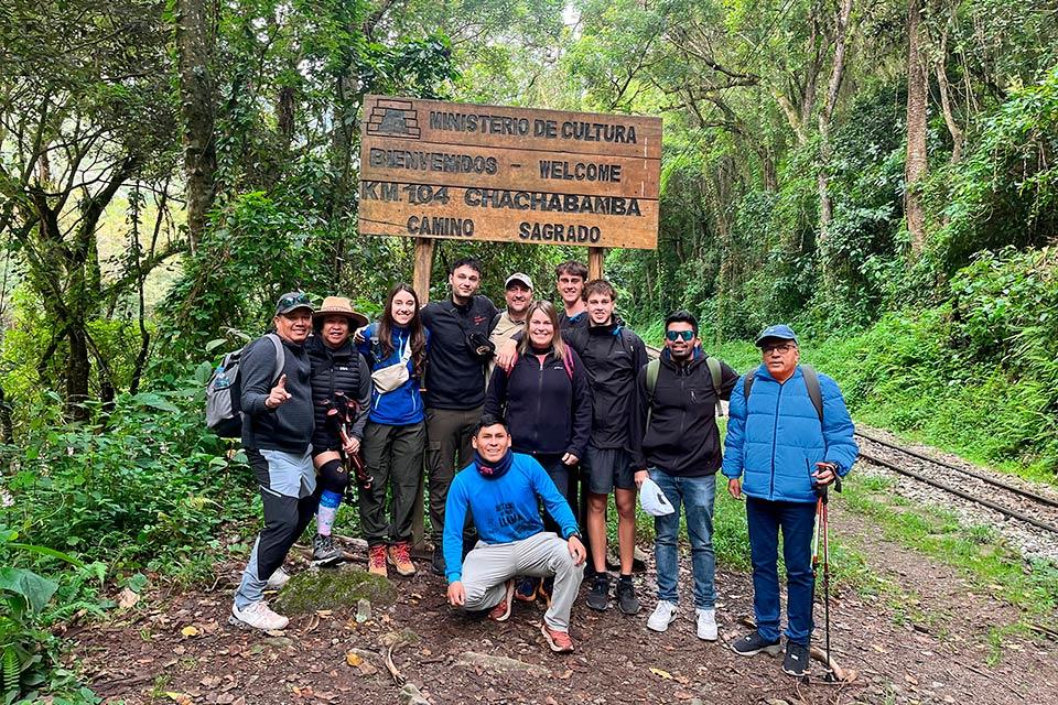 Grupo del Camino Inca de 1 día posando en el letrero de bienvenida de Km 104 (Chachabamba) | TreXperience