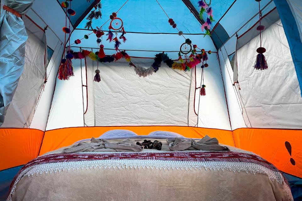 Camping tent interior with a bed and Andean decor on the Luxury Inca Trail | TreXperience