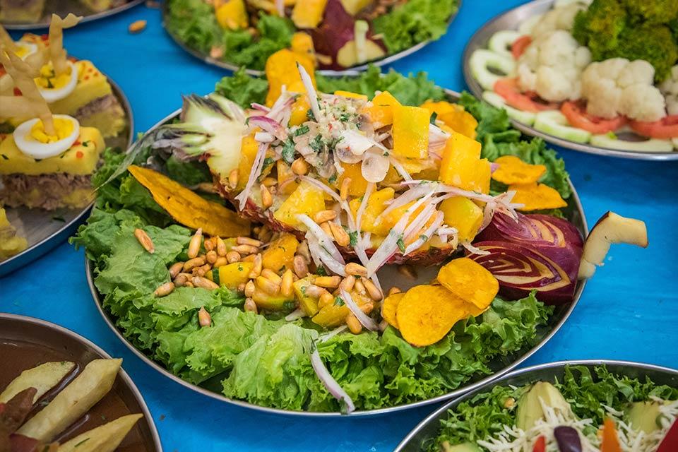 Plato servido en piña con mezcla de ingredientes y guarniciones frescas en buffet | TreXperience