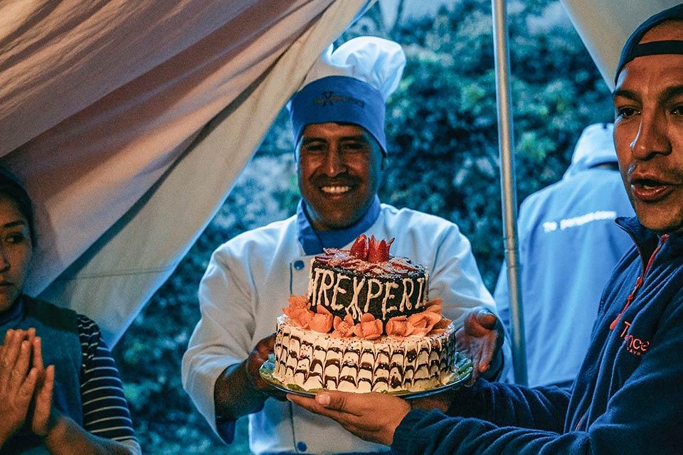 Chef del campamento presentando una torta de celebración dentro de una carpa (Camino Inca 5 días, versión extendida) | TreXperience
