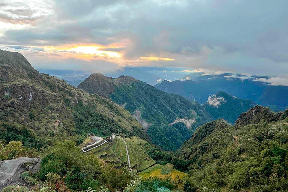 aisaje andino al atardecer con valle entre montañas y terrazas incas en la ladera (Camino Inca 4 días) | TreXperience