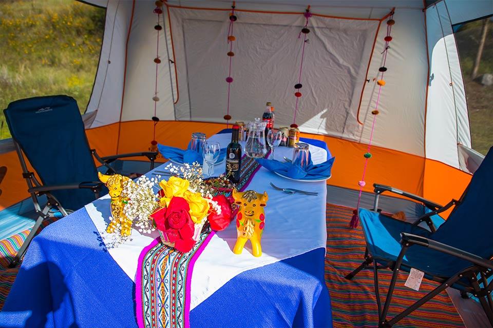 Dining table set inside a tent with Andean textiles (Luxury Short Inca Trail) | TreXperience
