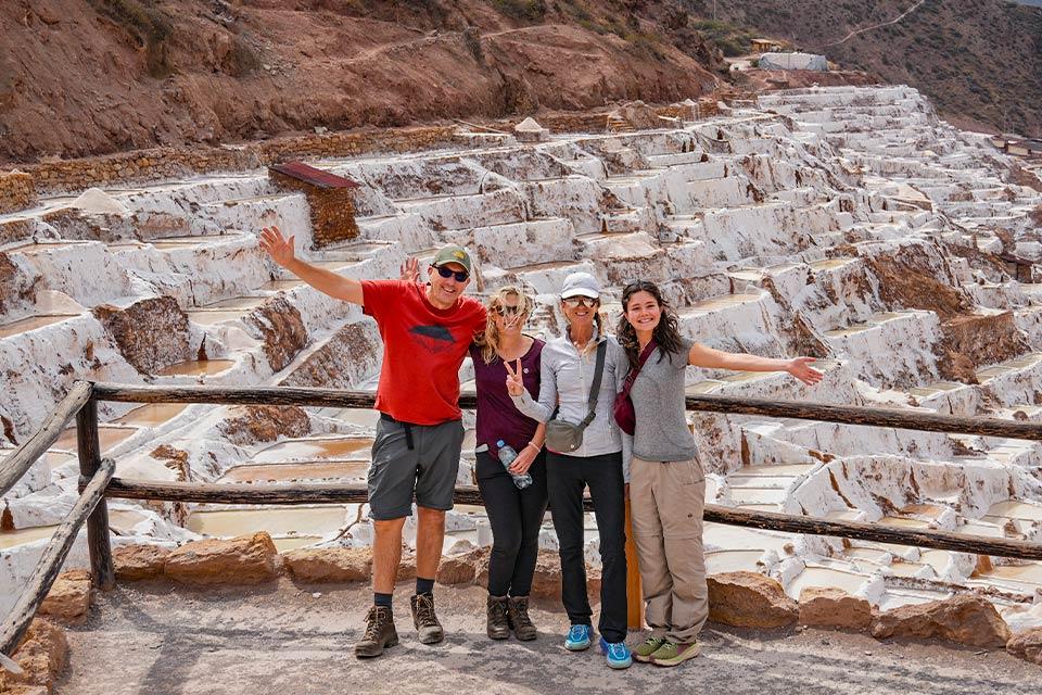 Traveler group posing with a panoramic view of the Maras Salt Mines (Maras, Moray & Chinchero half-day tour) | TreXperience
