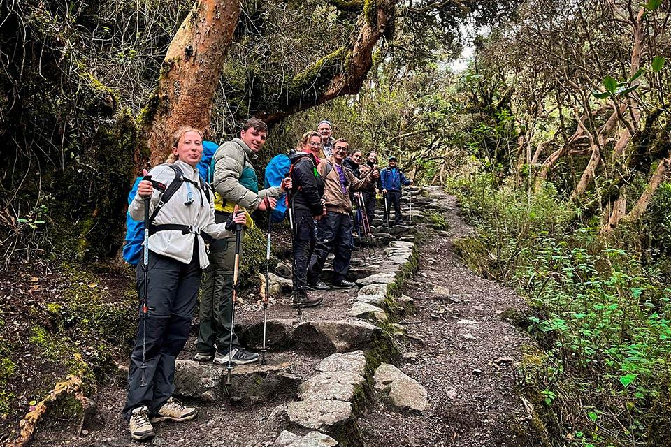 Grupo de senderistas posando en escalinatas de piedra en el bosque nuboso del Camino Inca (Tour privado del Camino Inca 4 días) | TreXperience