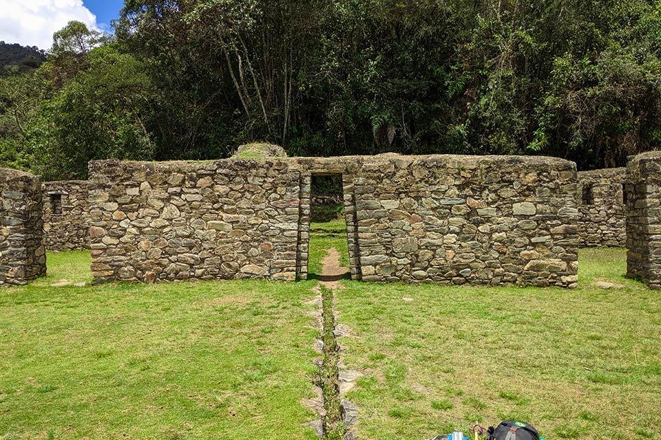 Stone wall with a central doorway and grass in front at Llactapata ruins, Salkantay Trek 5 Days to Machu Picchu | TreXperience