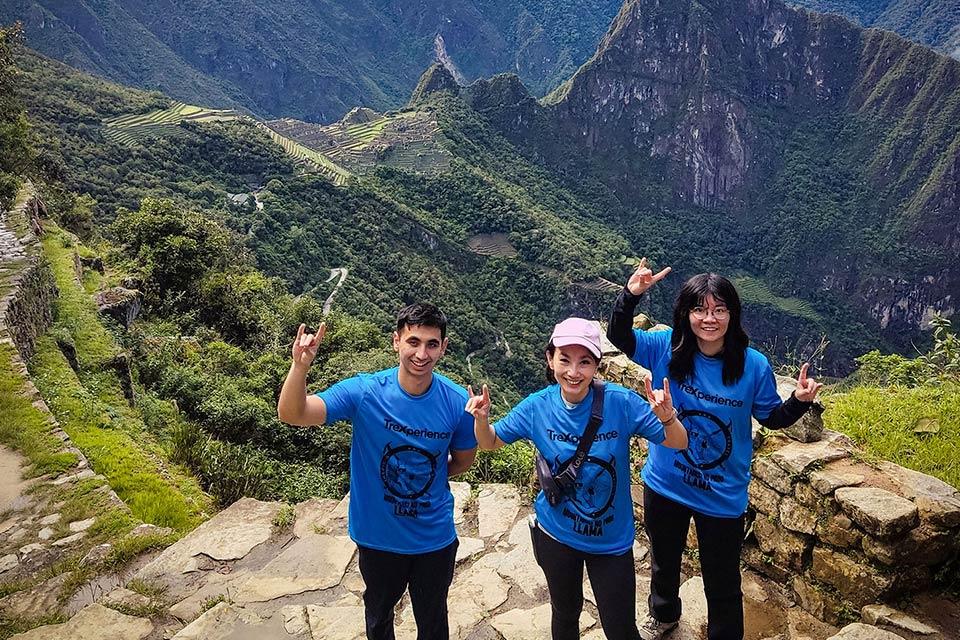 Traveler group posing with a panoramic view of Machu Picchu from the Short Inca Trail | TreXperience