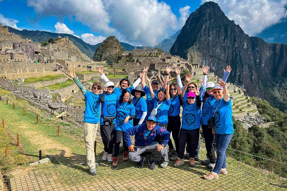 Traveler group celebrating at Machu Picchu with Huayna Picchu in the background (Ultimate Inca Trail Tour, 5 days) | TreXperience