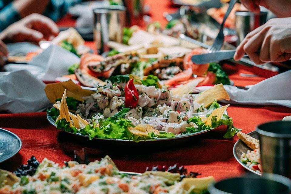 Ceviche platter at the center of the table with onion, lettuce, and crispy pieces as it’s being served, Cachicata Inca Quarry Trek to Machu Picchu 4 Days 3 Nights | TreXperience
