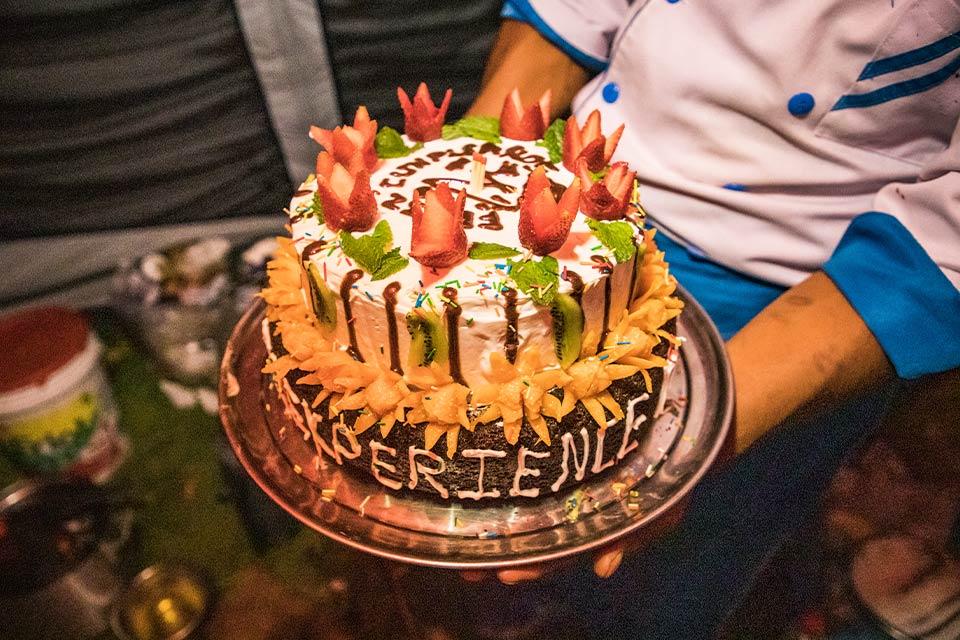 Chef holding a cake decorated with strawberries and the TreXperience name on a metal tray, Choquequirao Machu Picchu 7 Days Trek | TreXperience