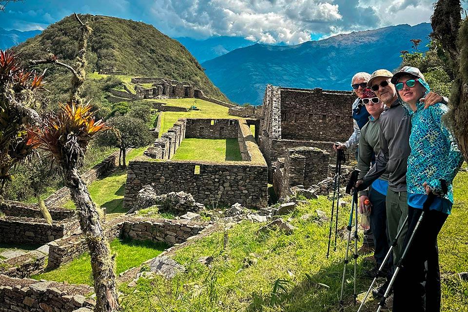 Group of hikers visiting the Choquequirao archaeological complex beside stone terraces and walls, Choquequirao Trek to Machu Picchu 6 Days | TreXperience