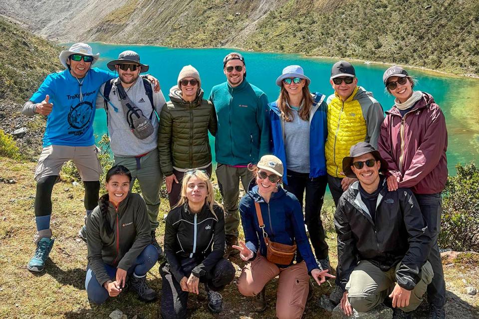 Grupo de excursionistas posando frente al lago turquesa Humantay | TreXperience