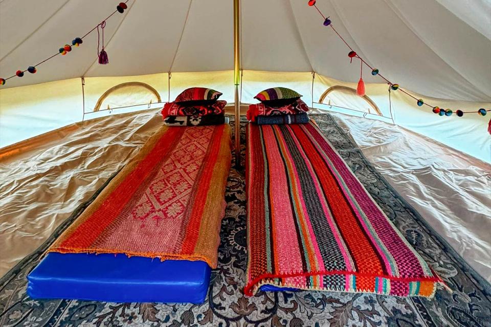 Interior de la tienda de Glamping Salkantay con dos camas y mantas coloridas | TreXperience