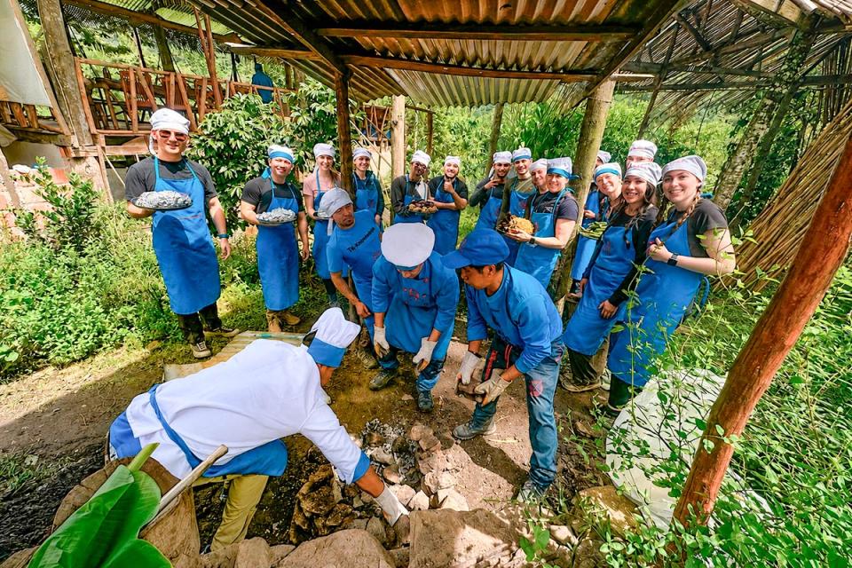 Viajeros preparando el plato tradicional de Pachamanca cocinado bajo tierra | TreXperience