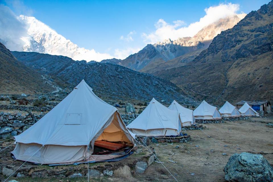 Campamento con carpas blancas en un valle de montaña frente al Salkantay | TreXperience