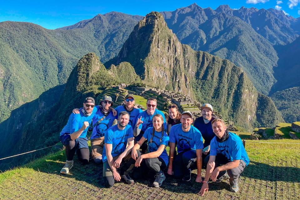 Grupo de viajeros posando con vista panorámica de Machu Picchu | TreXperience