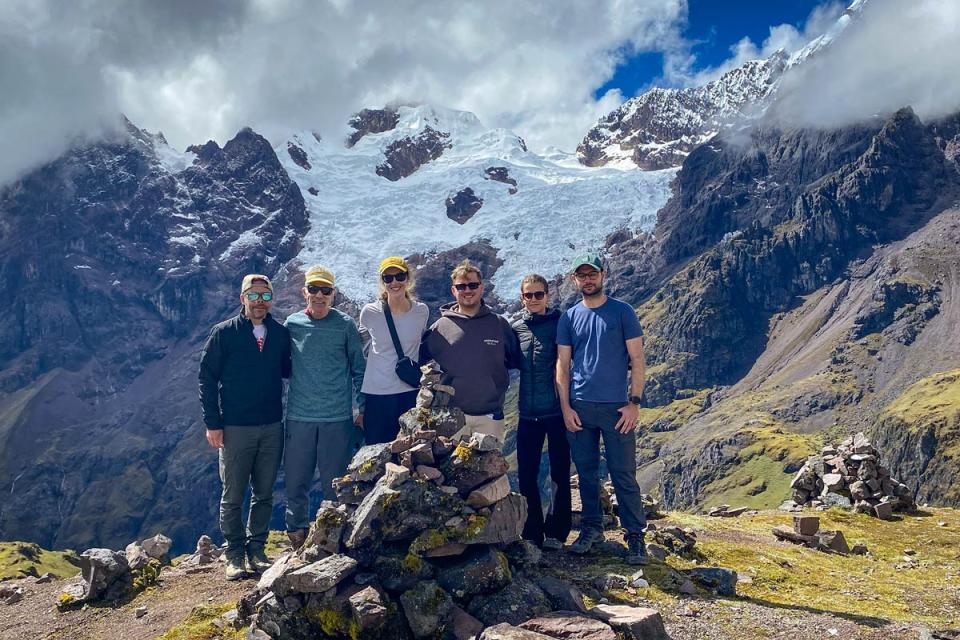 Grupo de excursionistas posando frente a una montaña nevada y un glaciar en un paisaje andino | TreXperience